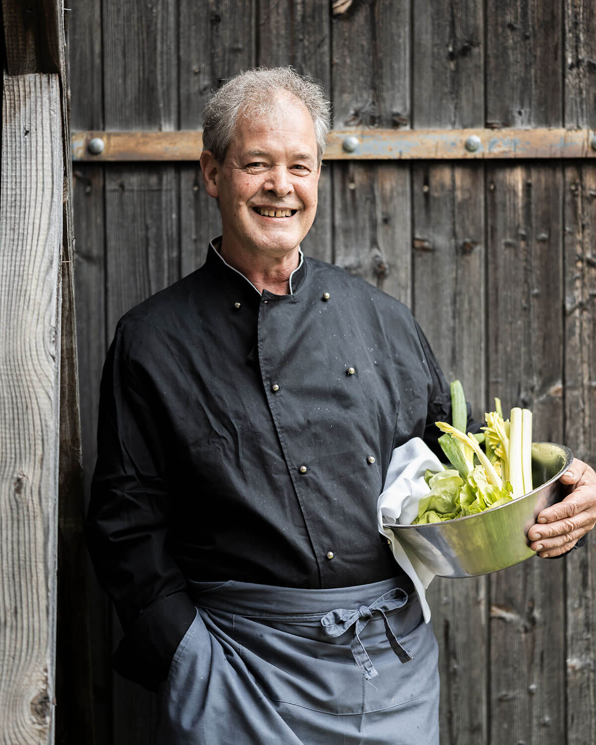 Il padrone di casa Walter tiene in mano una ciotola di verdure - Naturhotel Miraval